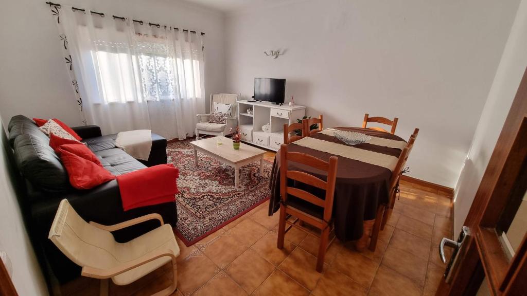 un soggiorno con divano e tavolo di Zinha's Guest House a Moledo