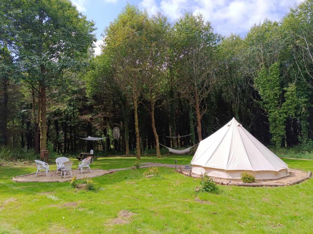 Tienda en un campo con mesa y sillas en tente nature, en Plouray