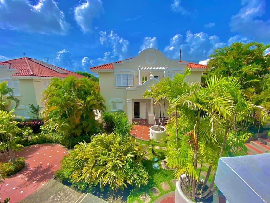 a house with palm trees in front of it at Tranquil Townhome, close to beach & dining in Saint James