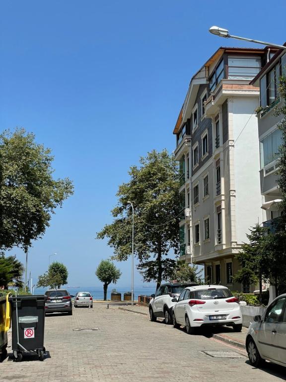 eine Straße mit Autos, die vor einem Gebäude geparkt sind in der Unterkunft Deniz Apartment in Yalova