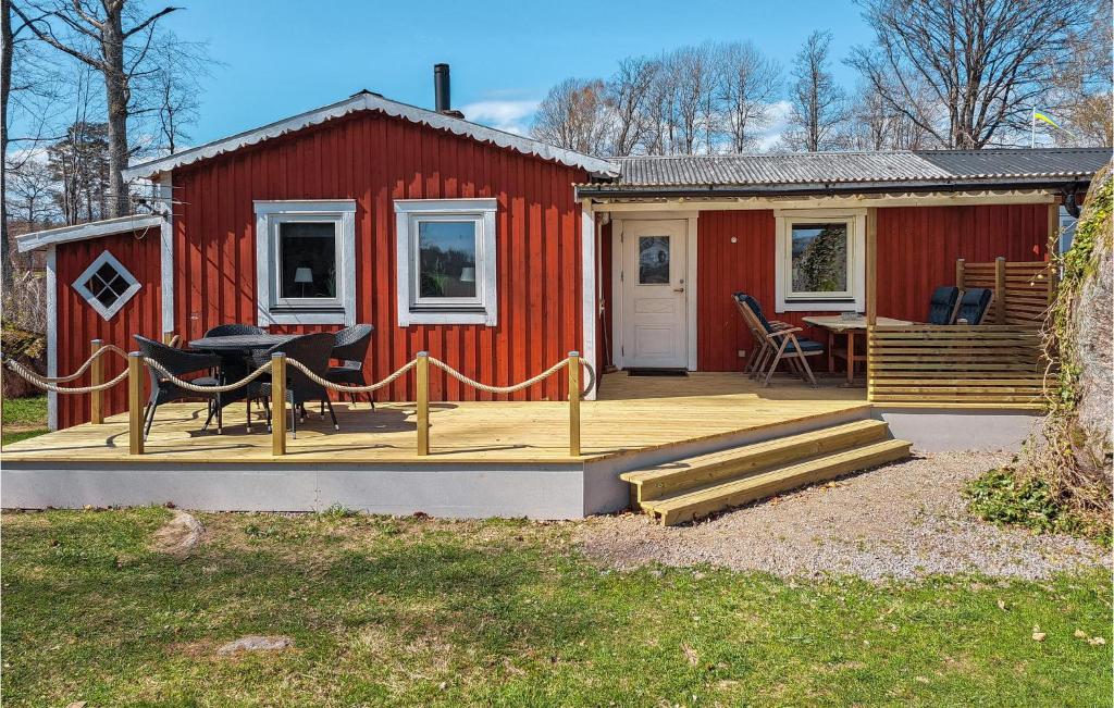 Casa roja con terraza con mesa y sillas en Gorgeous Home In Lnashult With Wifi, en Lönashult