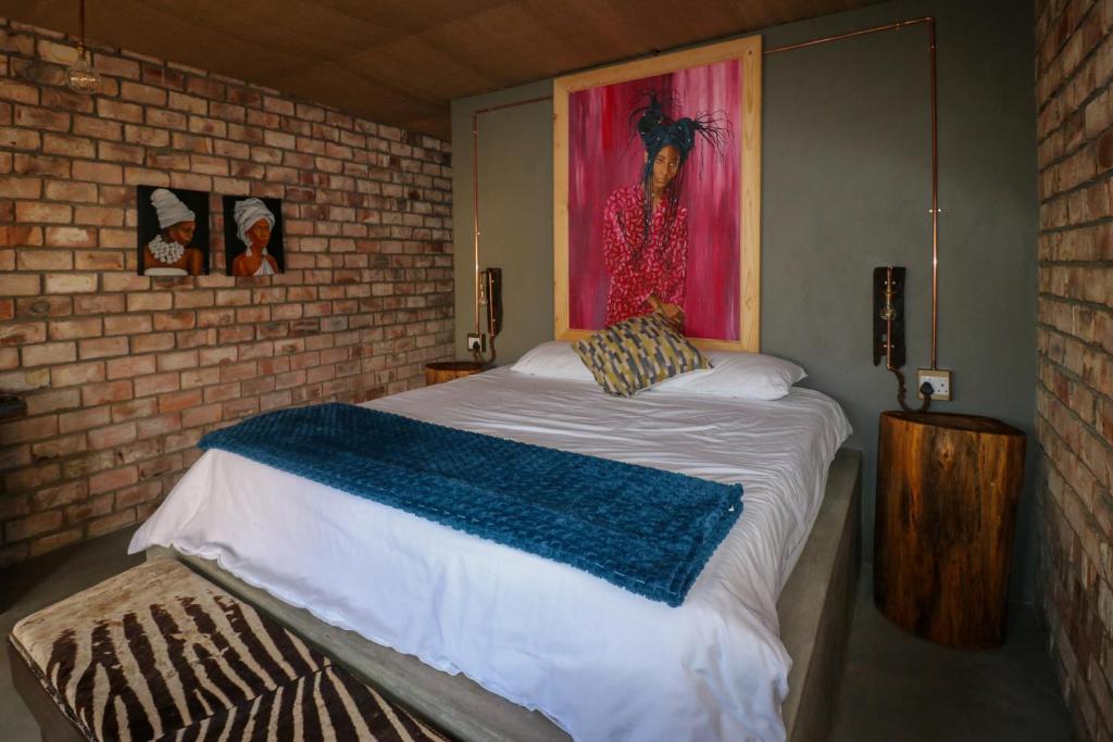 a bedroom with a bed with a painting on the wall at The Desert House in Uis