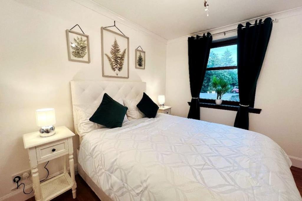 um quarto com uma cama branca e uma janela em A Stylish Two-Bedroom Flat-Free Parking-CityCentre em Aberdeen