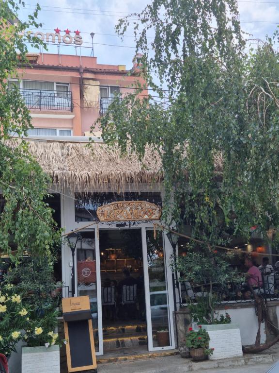 a store with a straw roof in front of a building at Vromos Guest Rooms in Chernomorets