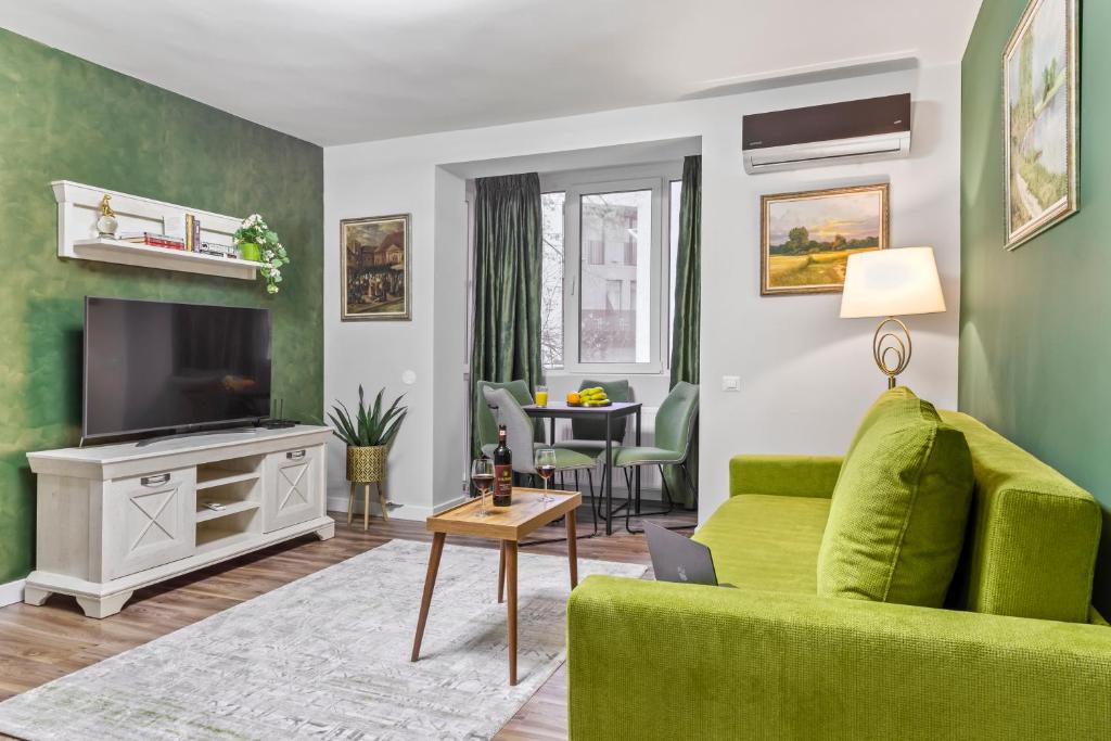 un soggiorno con divano verde e TV di Cozy by Art City a Bucarest