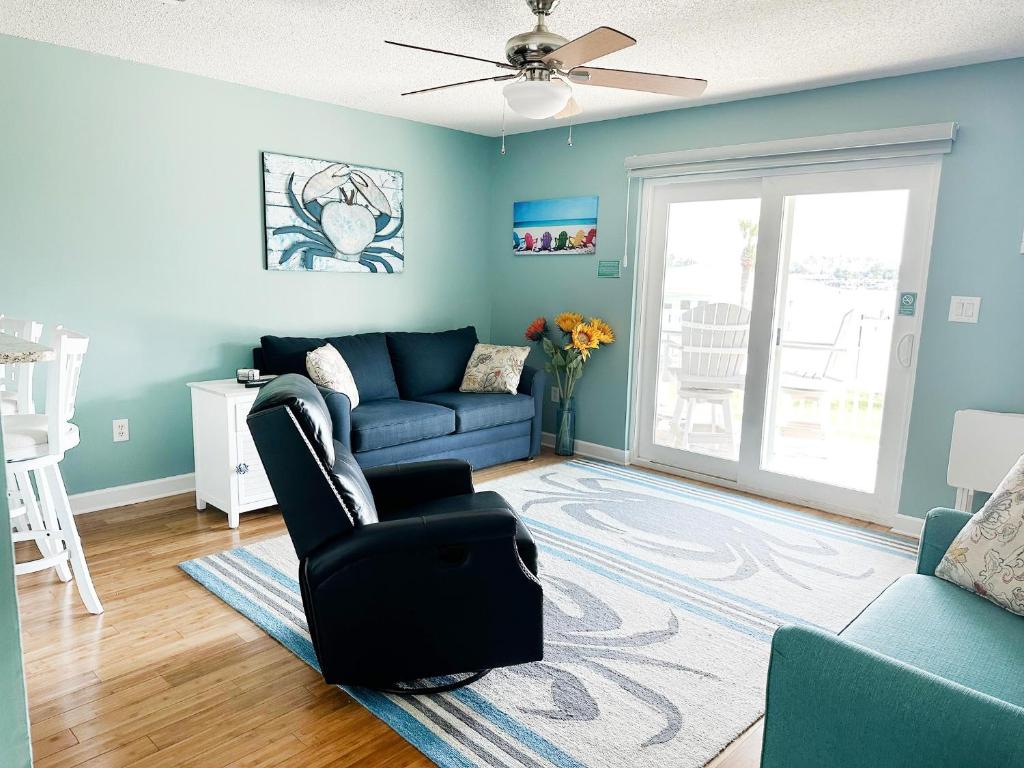 un soggiorno con divano blu e sedia di Crabby Lagoon C104 a Panama City Beach