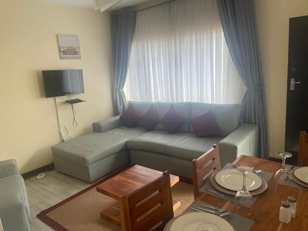 uma sala de estar com um sofá e uma mesa em @Jackie’s Avondale 2 bed flat at Harrow court em Harare