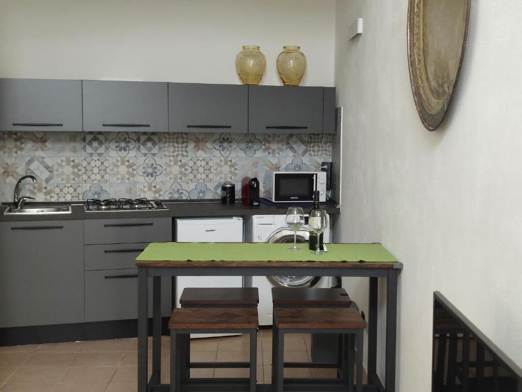 a kitchen with a table with a sink and a microwave at la chiocciola in Mesagne