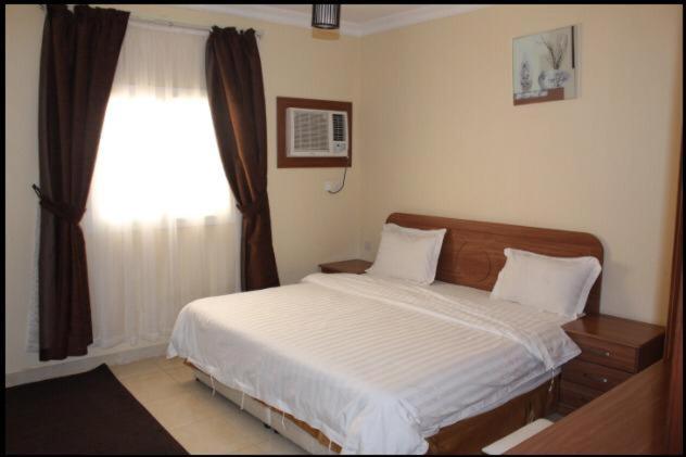 a bedroom with a large bed and a window at Zahret Al Madinah in Al Madinah