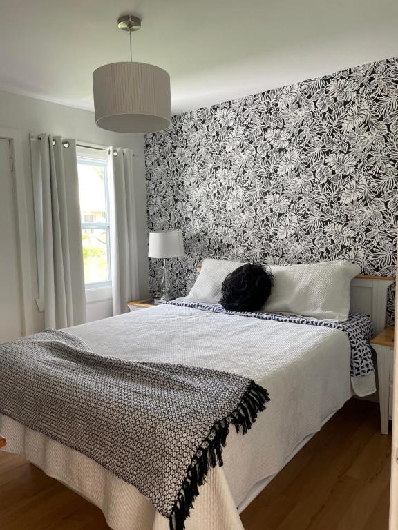 a black cat laying on a bed in a bedroom at Chalets Plage St-Jean 2 in Saint-Jean