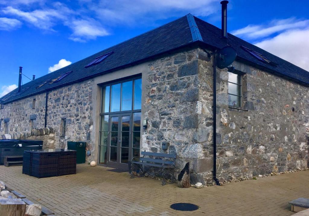 a stone building with a large window at Osprey Lodge in Kingussie