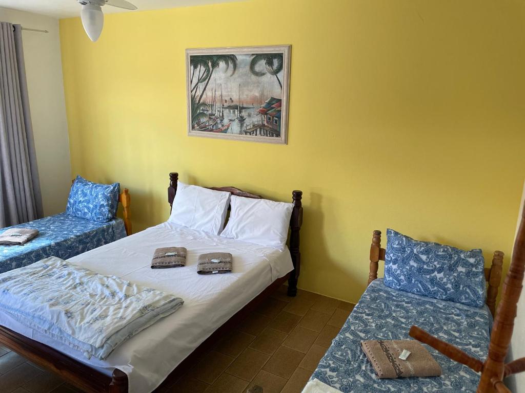 a bedroom with a bed and two blue chairs at Pousada Cirandinha - P1 in Itajaí