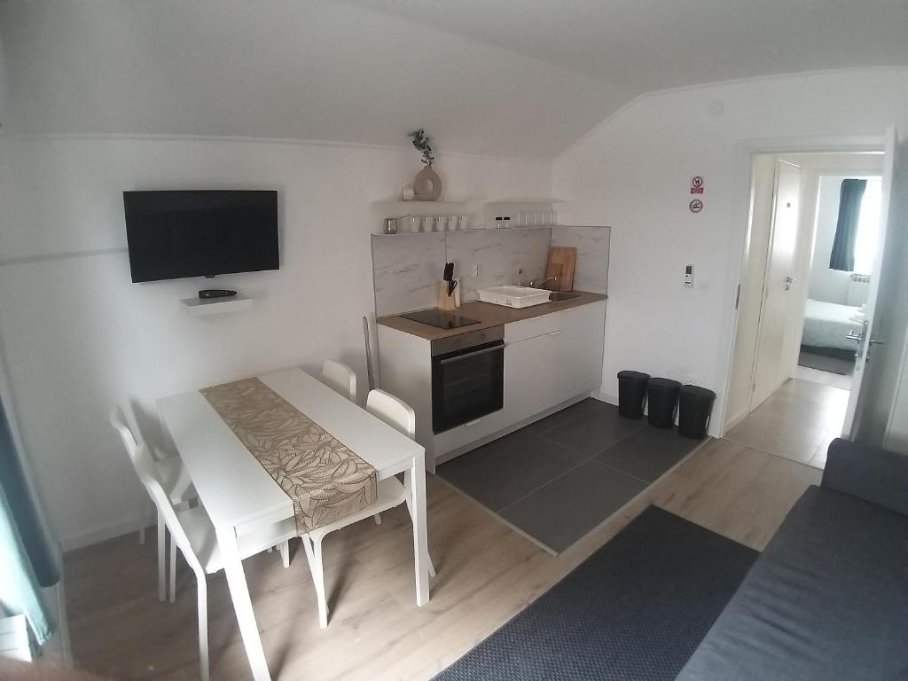 a small kitchen with a white table and a television at Studio Apartment Lenchy in Zagreb