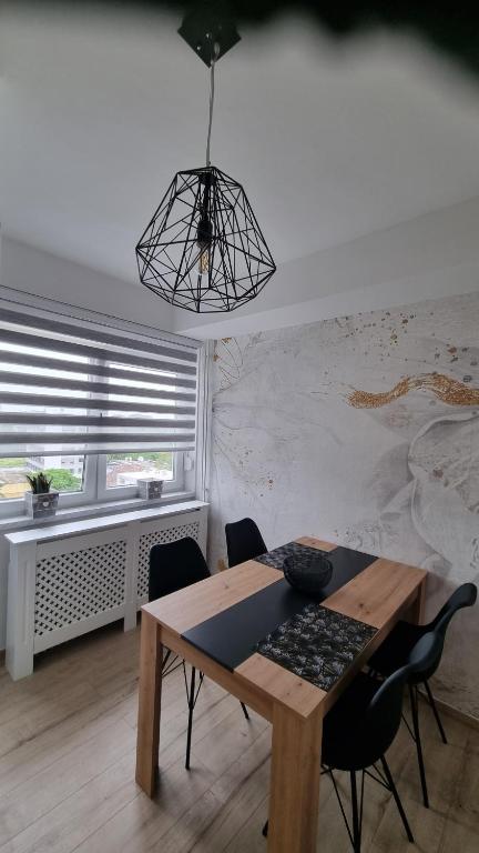 uma sala de jantar com uma mesa de madeira e cadeiras em Apartman Nora em Čakovec