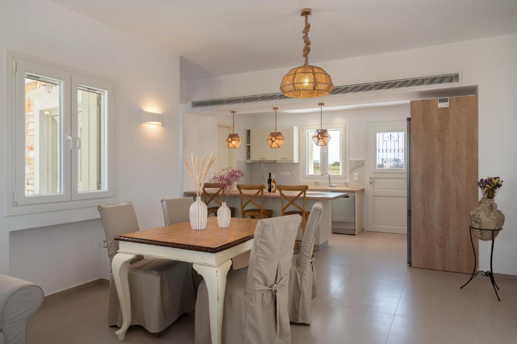 a dining room and kitchen with a table and chairs at Santa Maria Mare in Naousa