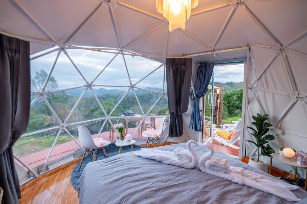 ein Schlafzimmer mit einem Bett und einem großen Fenster in der Unterkunft เดอะเนเจอร์ ม่อนแจ่ม The nature camping monjam in Mon Jam