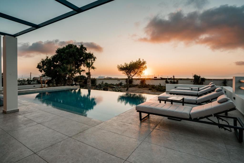 einen Pool mit einem Sofa und einem Tisch in der Unterkunft Echo Villa in Fira