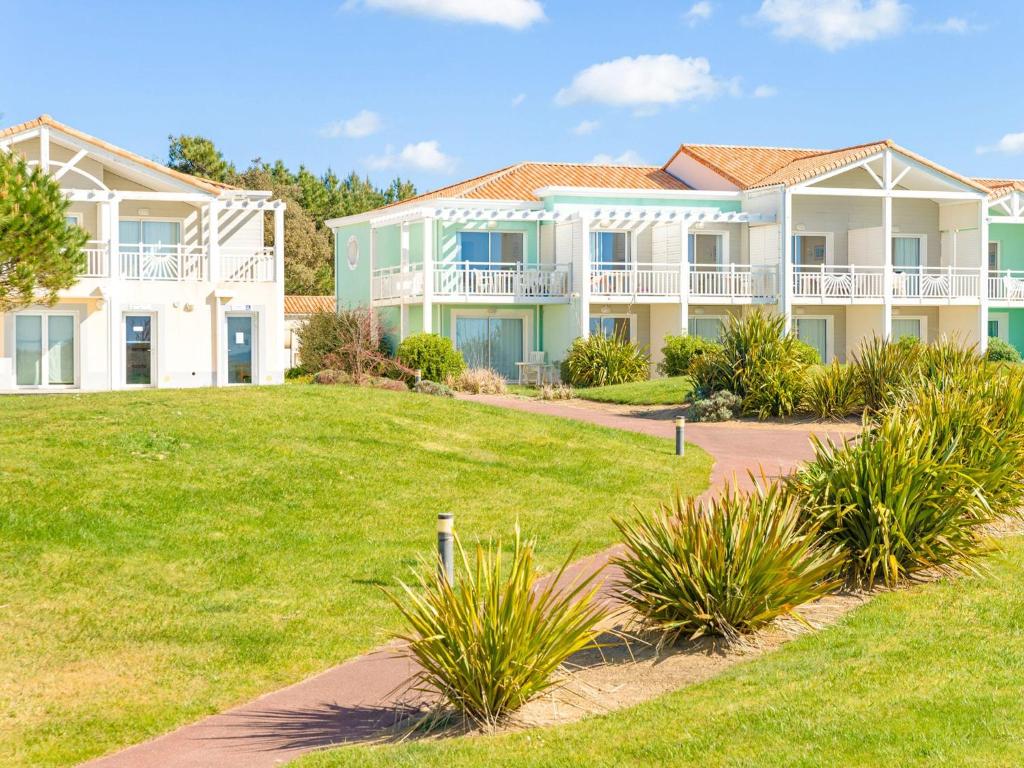 une grande maison avec une pelouse devant dans l'établissement Apartment in France near Scenic Coastline, à Château-dʼOlonne