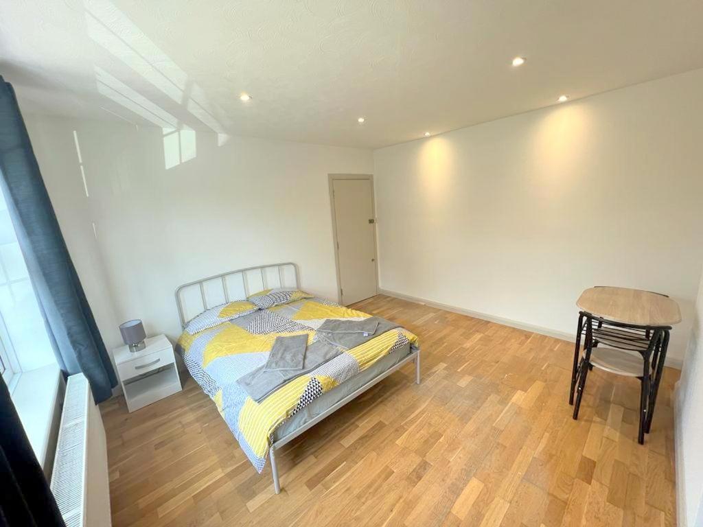 una camera con letto, tavolo e sedia di Studio Apartments in Sutton (South London) a Cheam