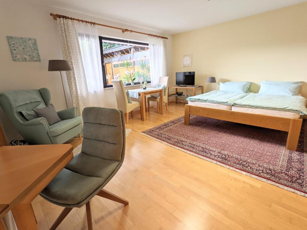 a living room with a bed and a table and chairs at Ferienwohnung Fischer in Unterreichenbach