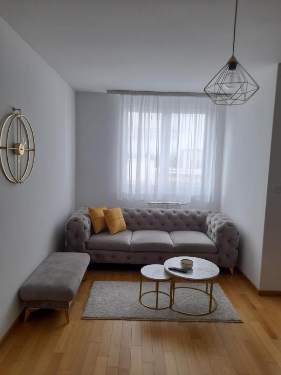 uma sala de estar com um sofá e uma mesa em Apartman Lena em Banja Luka