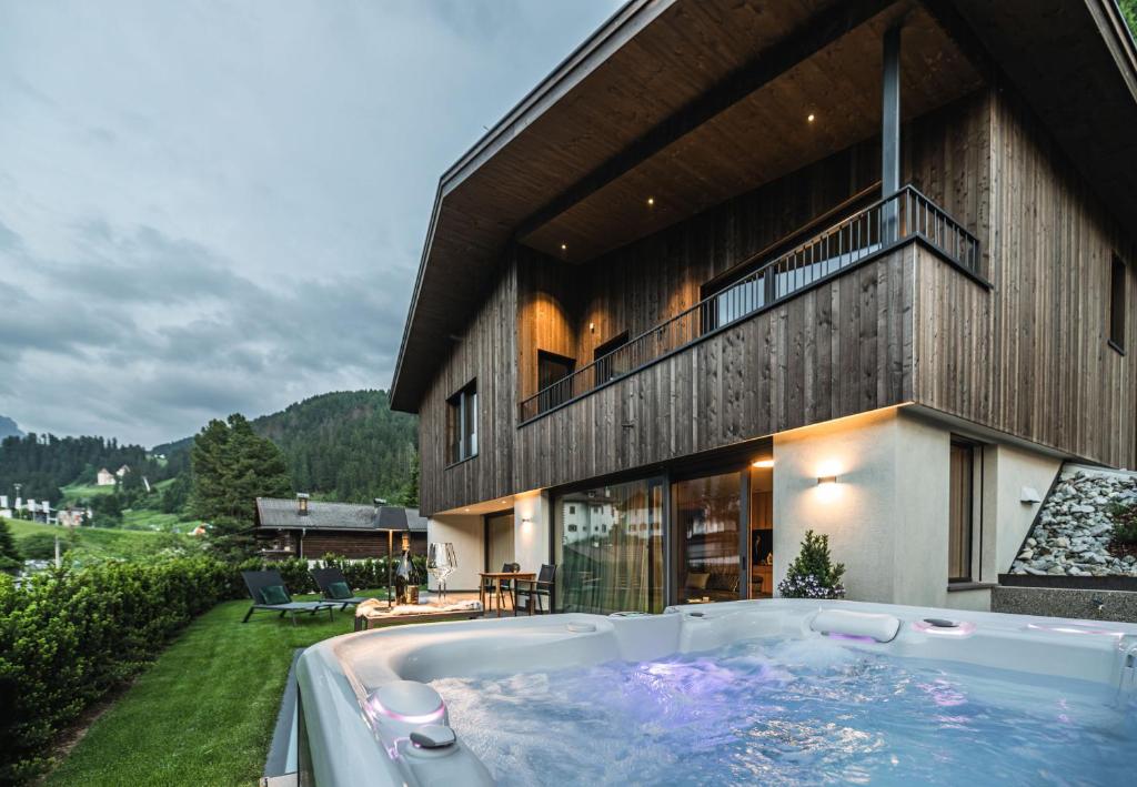a hot tub in front of a house at Amie Chalet in Santa Cristina in Val Gardena