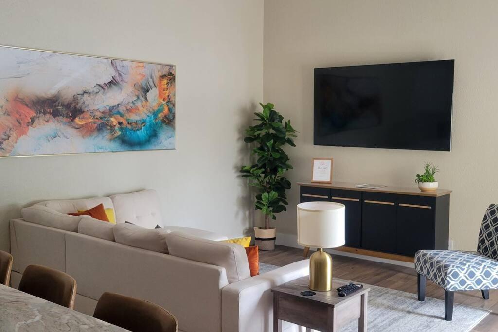 a living room with a couch and a flat screen tv at Fully Furnished Alluring Turn Key Luxury Oasis in Wellington