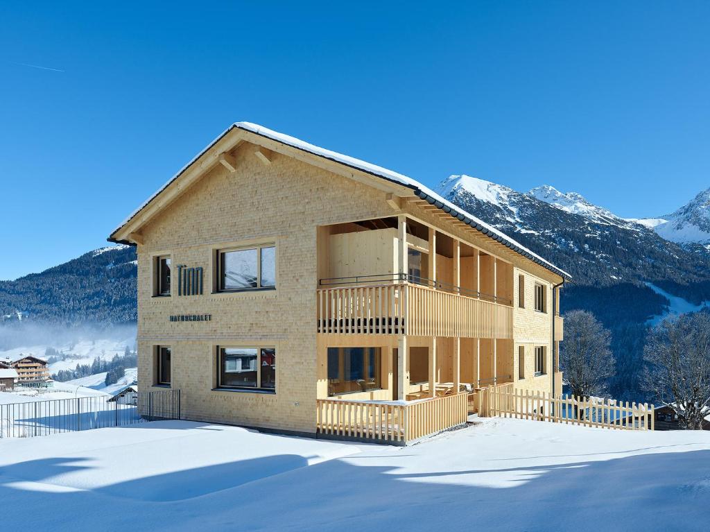 een huis in de sneeuw met bergen op de achtergrond bij Tinn Naturchalet in Mittelberg