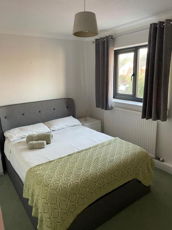 een slaapkamer met een bed met een deken en een raam bij 3 bedroom home in Nottage, Porthcawl in Nottage
