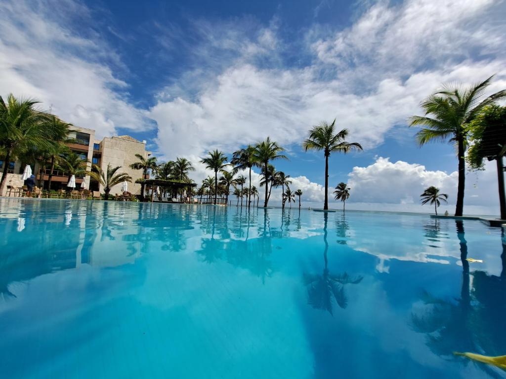 a large swimming pool with palm trees on a beach at Apto 3 quartos no Wai Wai - Cumbuco-Ce in Cumbuco