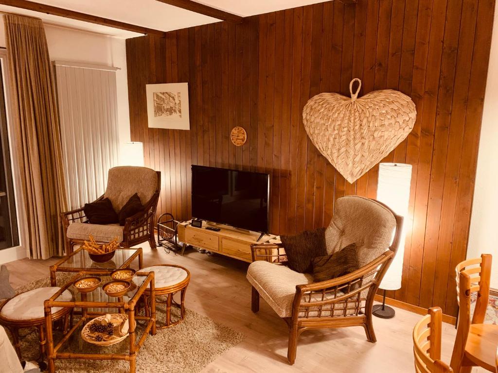 uma sala de estar com duas cadeiras e uma televisão em Appartement de vacances à Torgon em Vionnaz
