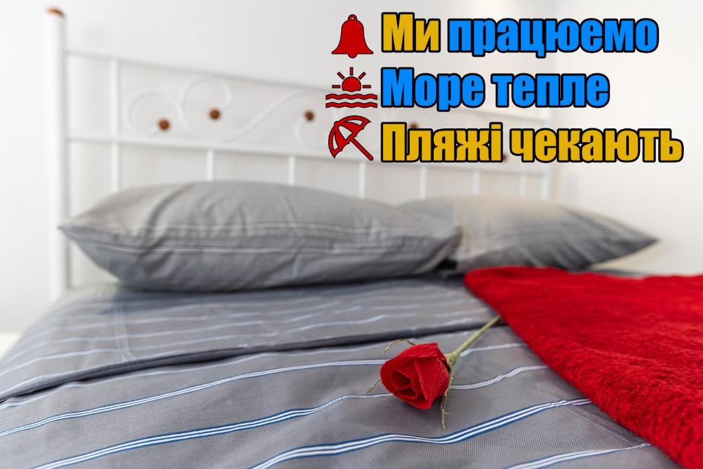 a red rose is sitting on top of a bed at "Ваша Квартира" - у самого Дерибаса! "Ваша Квартира" біля самого Дерибаса! in Odesa