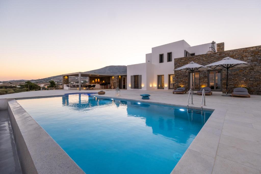 - une piscine en face d'une villa dans l'établissement Golden Bay luxury villas and suites, à Chrissi Akti