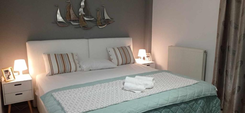 um quarto com uma cama branca com duas mesas de cabeceira em Demmy's Luxury Apartment em Orestias