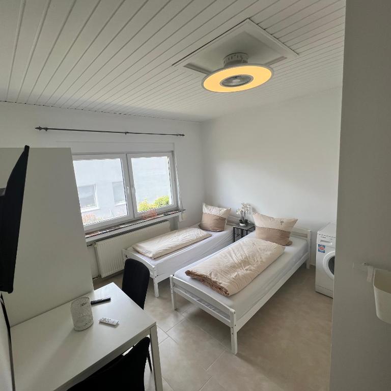 a white room with two beds and a window at Private Room in Hannover