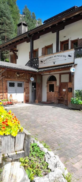 a building with a sign that reads synergy synergy merging at Fattoria Meneguto Agriturismo Degasper Giorgio in Cortina dʼAmpezzo