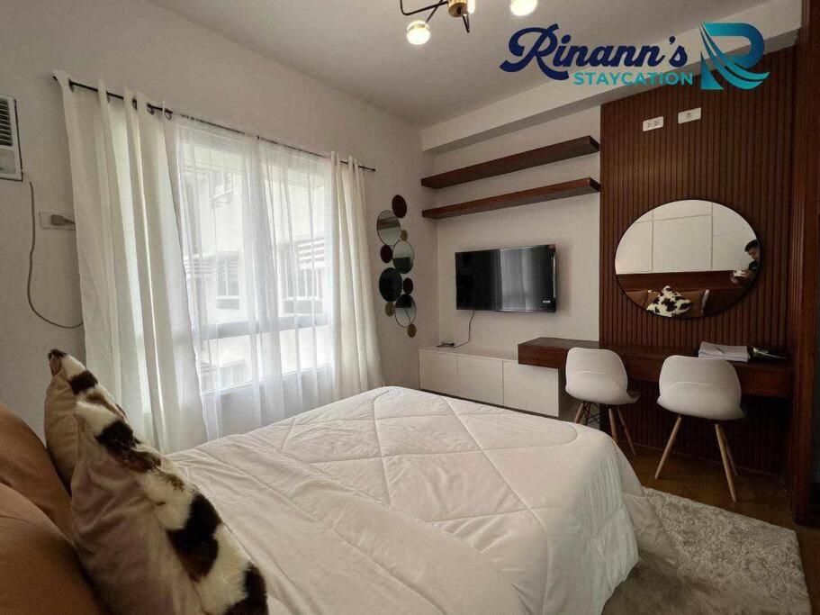 un dormitorio con una cama con un gato sobre ella en Rinann's Staycation Mesatierra Condotel Davao, en Davao City