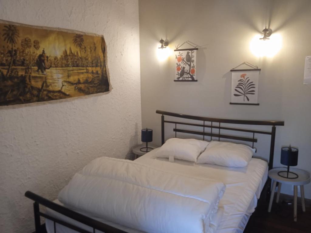 a bedroom with a bed and a painting on the wall at les figuiers et les rosiers proche puy du fou in Saint-Germain-de-Prinçay