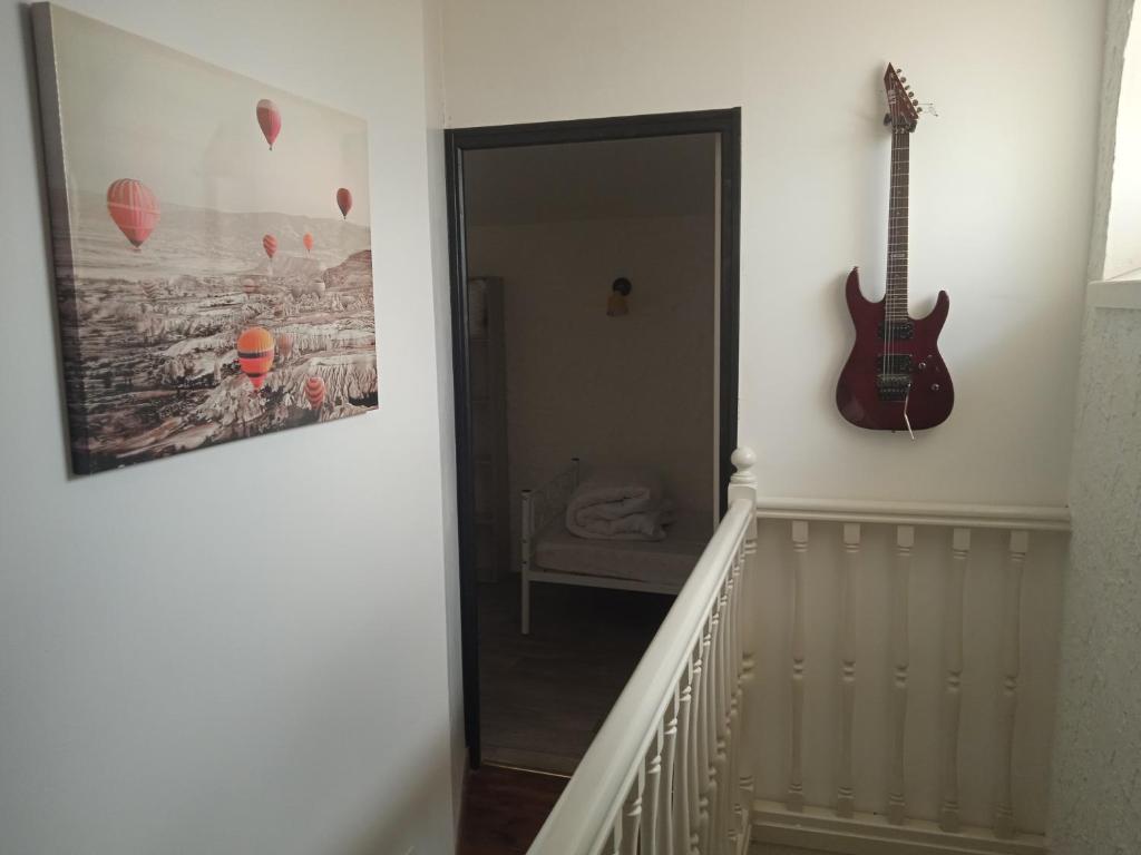 a hallway with a guitar hanging on a wall at les figuiers et les rosiers proche puy du fou in Saint-Germain-de-Prinçay