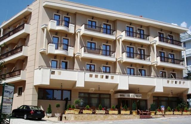 un grande edificio con un'auto parcheggiata di fronte di Elena Hotel a Kozani