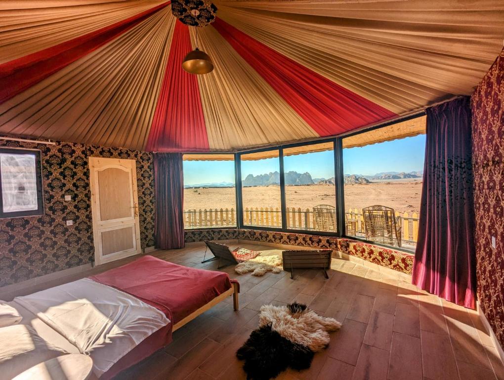 a bedroom with a bed with a view of the desert at Desert Magic Camp & Resort in Wadi Rum
