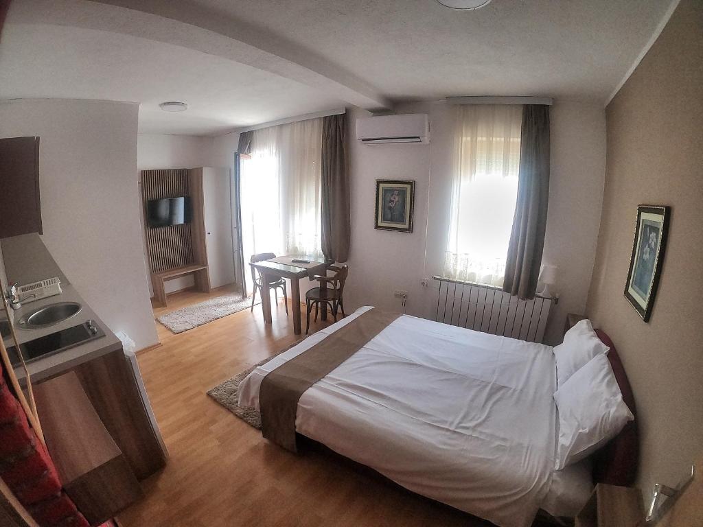 a bedroom with a bed and a kitchen and a table at Vila Papu in Kruševo