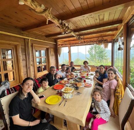 Eine Gruppe von Menschen, die an einem Tisch sitzen und Essen essen. in der Unterkunft Selin Yaşam Evi in Artvin