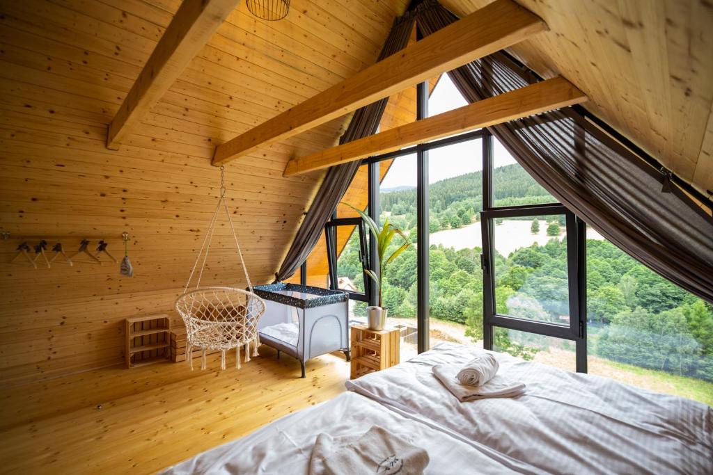 um quarto com uma cama numa casa de madeira em Osada Za gorami za lasami - domki z widokiem na Snieznik em Stronie Śląskie