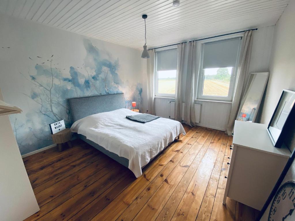 a bedroom with a bed and a painting on the wall at Ferienwohnung Wiesenblick in Faßberg