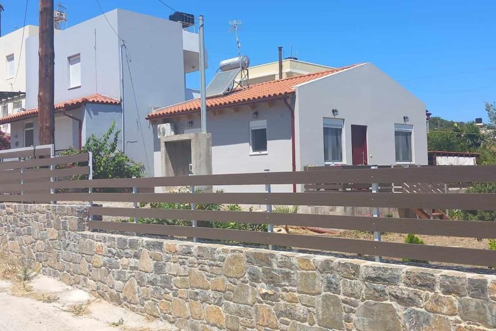 un edificio con una valla y una pared de piedra en Sweet Detached House, en Ierápetra