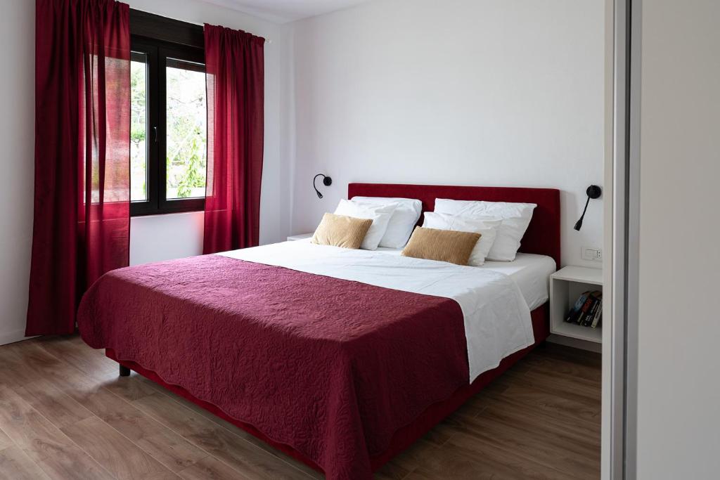 a bedroom with a large bed with red curtains at Sea Melody in Lopar
