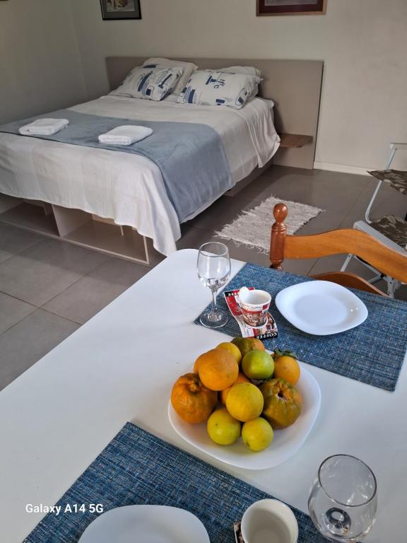 una mesa blanca con un plato de fruta. en Villa Holística, en Nova Petrópolis
