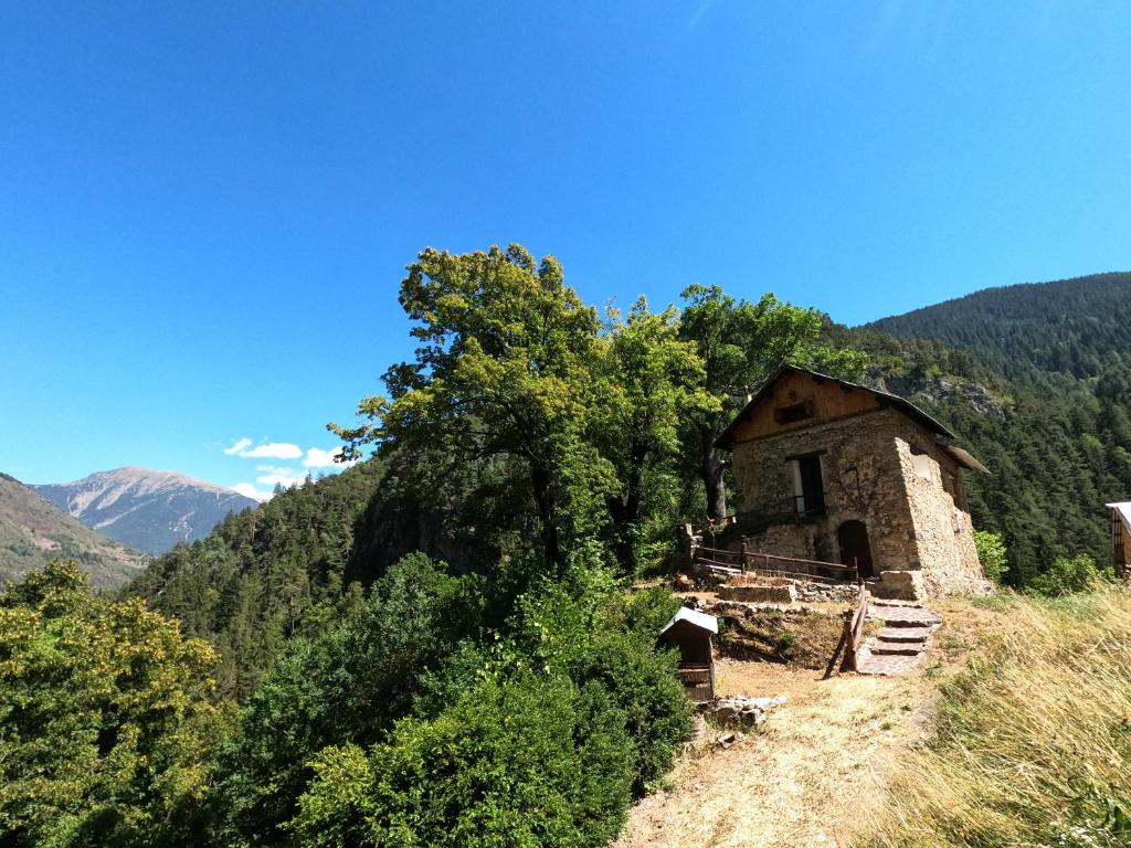 un vieux bâtiment sur le côté d'une montagne dans l'établissement Maison Maralpine, à Roubion