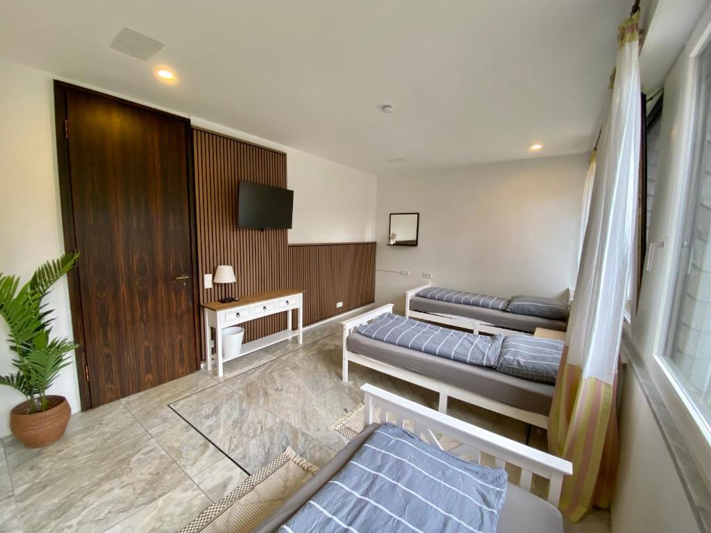 a hotel room with two beds and a tv at Villa Arche 2 in Neuenkirchen-Vörden